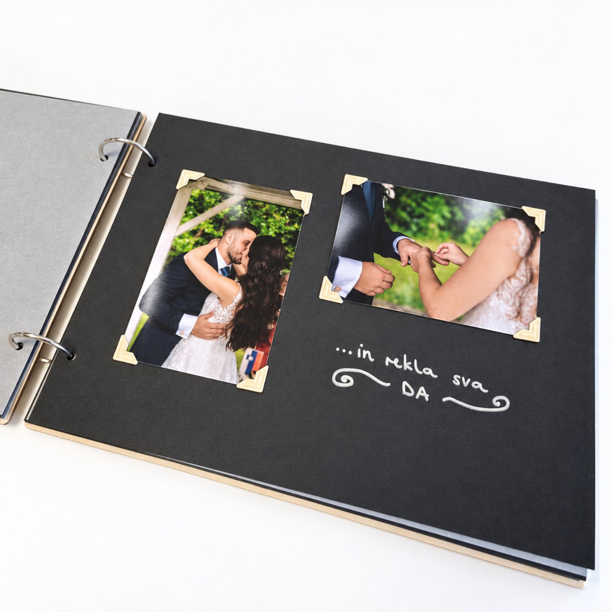 Odprt poročni album Najin dan s črnim listom, dvema poročnima fotografijama in napisom.
